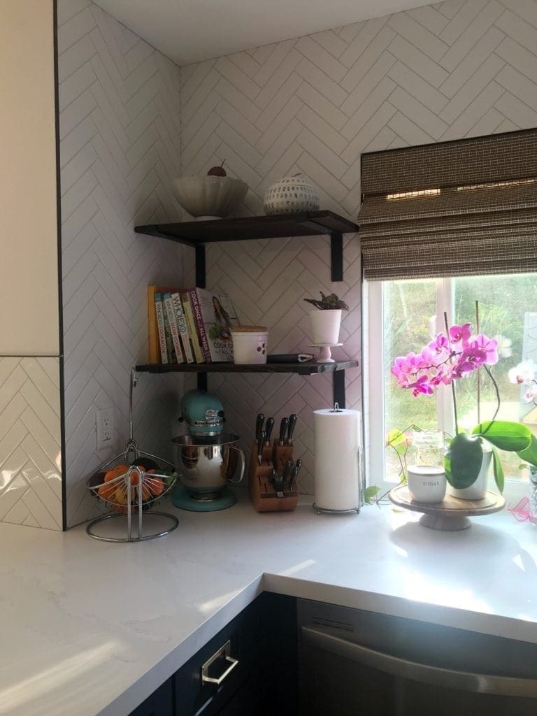 Before and After Kitchen Renovation with ideas and costs. See our farmhouse sink, herringbone backsplash with white subway tile and our DIY open shelving without changing our layout. Two-tone cabinets in woodgrain and blue. Including tips to get the most out of your budget. #kitcheremodel 