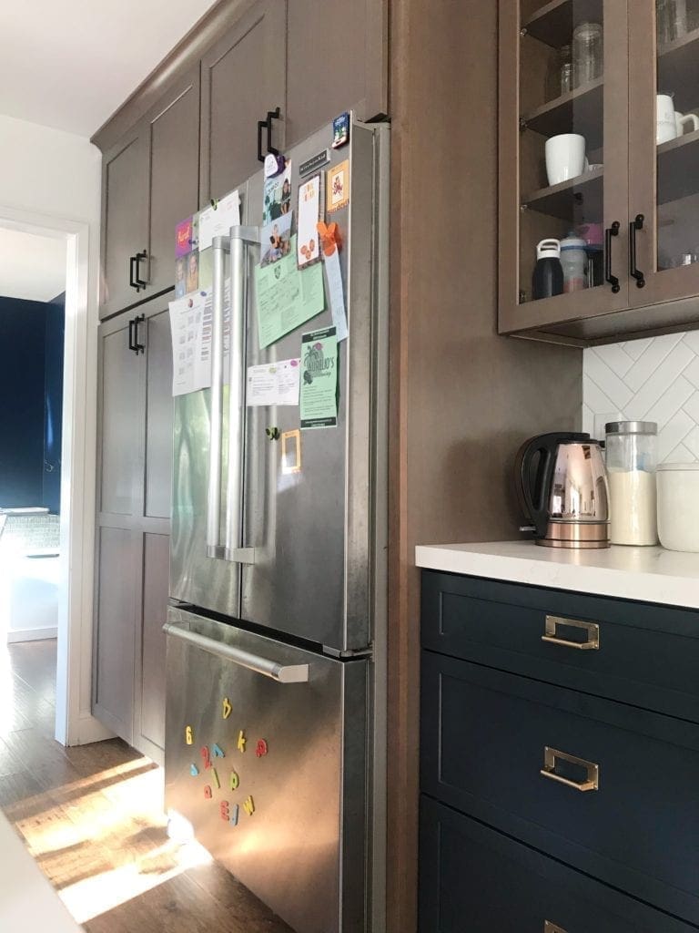 Before and After Kitchen Renovation with ideas and costs. See our farmhouse sink, herringbone backsplash with white subway tile and our DIY open shelving without changing our layout. Two-tone cabinets in woodgrain and blue. Including tips to get the most out of your budget. #kitcheremodel 