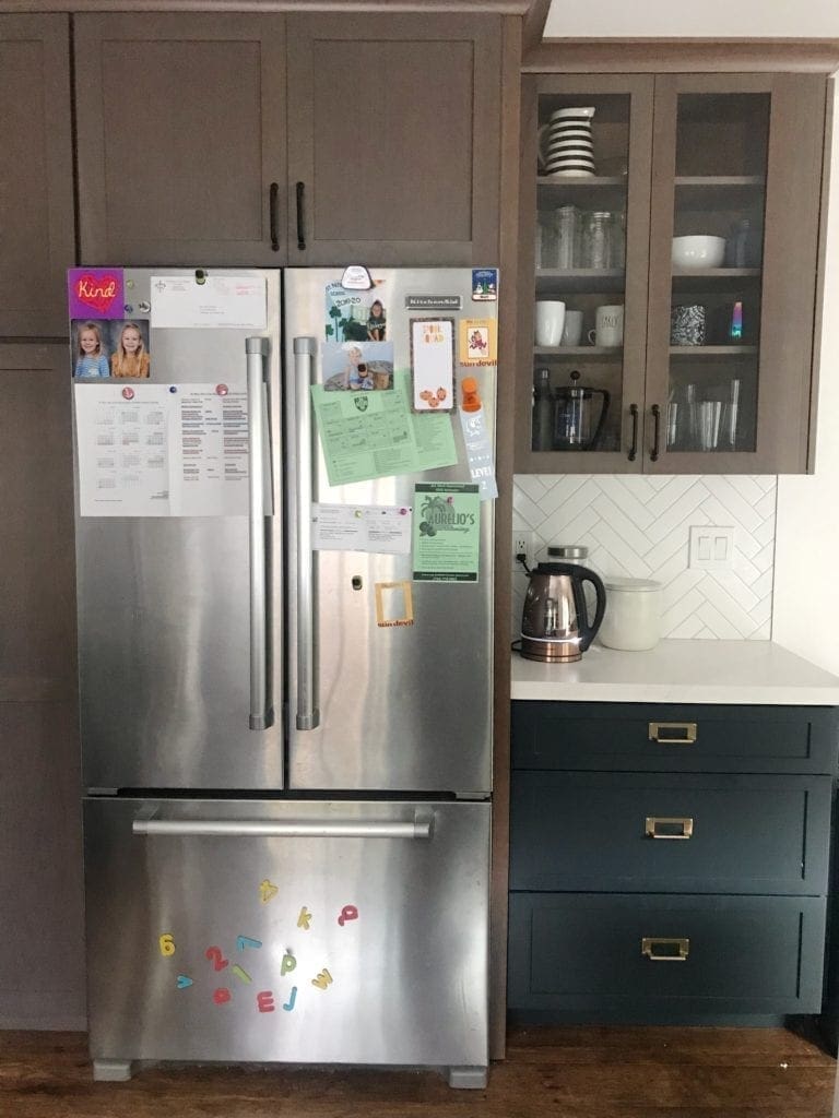 Before and After Kitchen Renovation with ideas and costs. See our farmhouse sink, herringbone backsplash with white subway tile and our DIY open shelving without changing our layout. Two-tone cabinets in woodgrain and blue. Including tips to get the most out of your budget. #kitcheremodel 